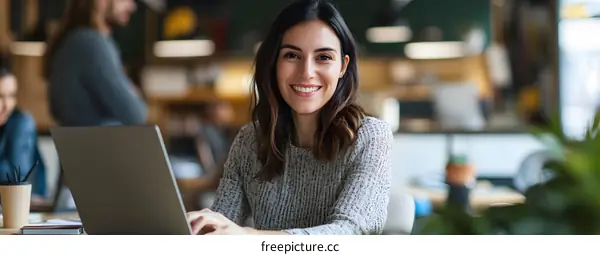 Smiling Woman Working on Laptop in Modern Office