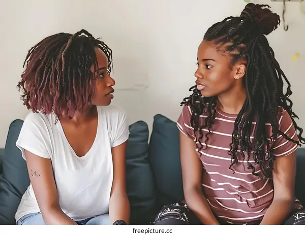 Two African American Women Sitting On A Couch Talking