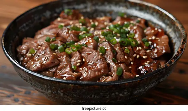 Bowl of Sliced Beef with Sesame Seeds and Green Onions