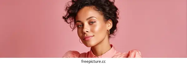 Portrait of young woman with curly hair and pink blouse