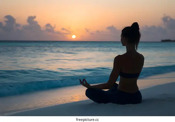 Silhouette of a Woman Meditating on the Beach at Sunset