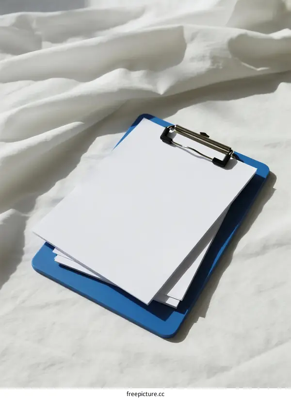 Blue Clipboard with White Paper on Soft White Textile