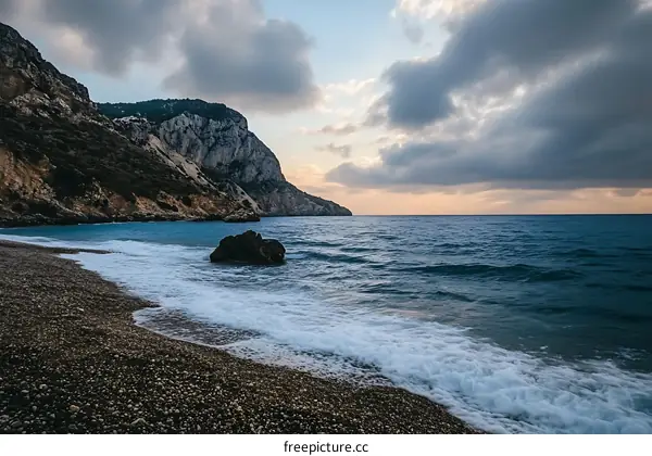 Seashore with Rocky Cliff and Cloudy Sky