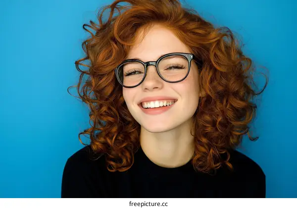 Smiling Woman with Curly Red Hair and Glasses
