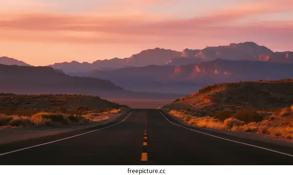Scenic road at sunset with mountains in the distance