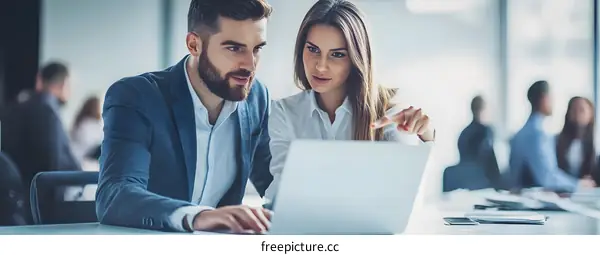 Business Professionals Working Together on Laptop in Modern Office