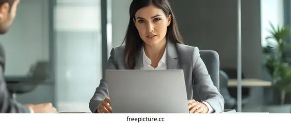 Businesswoman Working On Laptop During Meeting