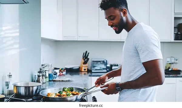 African American Man Cooking Vegetables In Kitchen