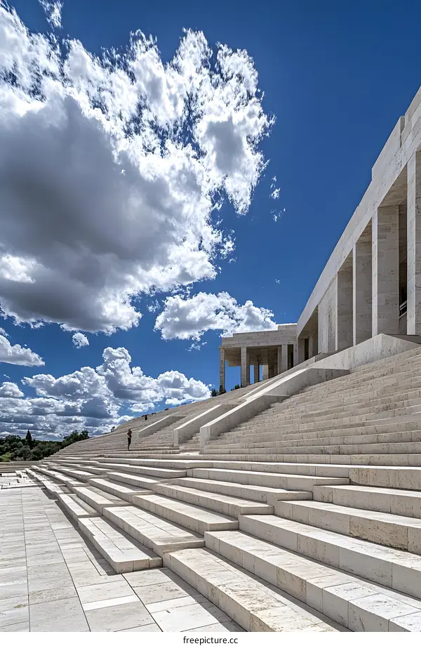 Modern Stone Stairway Leading Up to a Building with a Blue Sky and White Clouds