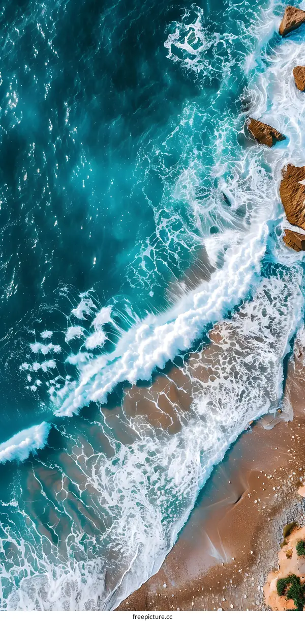 Aerial View of Ocean Waves Crashing on Sandy Beach