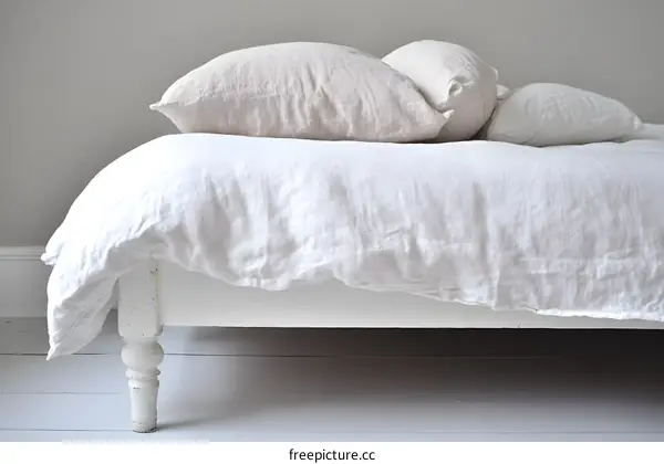 White Linen Bedding on a Wooden Bed Frame