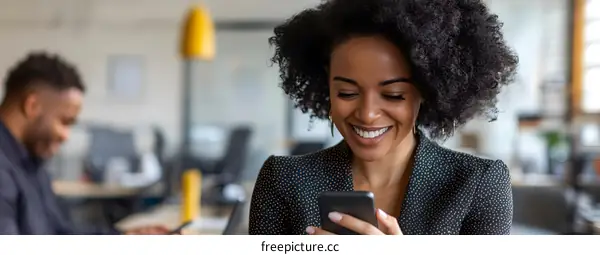 Smiling Black Woman in Office Using Smartphone