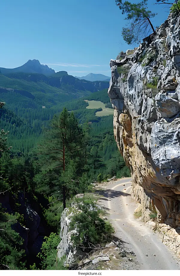 A dirt road winds through a mountain pass