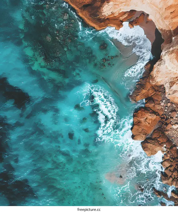 Aerial View of Turquoise Water Crashing Against Rocky Shore