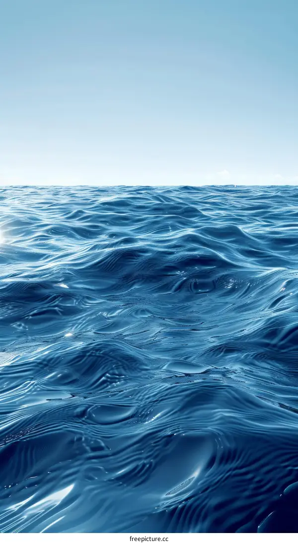 Deep blue ocean surface with bright sunlight reflecting off the waves