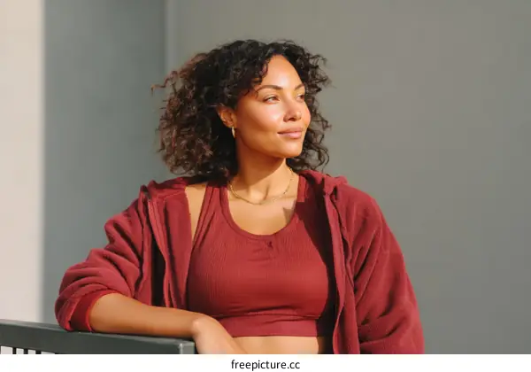 Thoughtful Woman in Burgundy Sporty Outfit