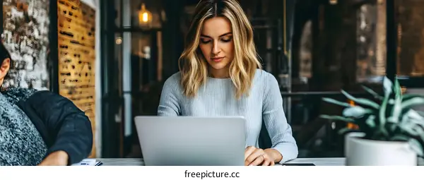 Woman Working on Laptop in Office Setting