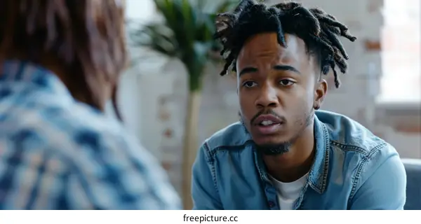 A young African-American man is talking to a woman