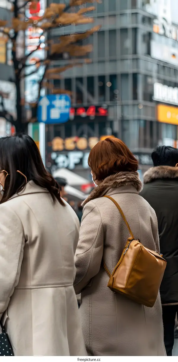 Two Women Walking in the City Street with a View of Buildings