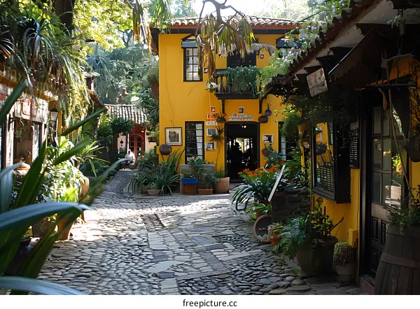 Cobblestone Pathway Leading Through a Lush Garden With Yellow Buildings