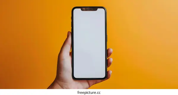Hand Holding Smartphone with White Screen on Yellow Background