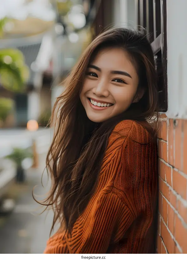 Smiling Asian Woman Leaning Against a Brick Wall