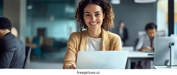 Smiling Woman Working On Laptop in Office