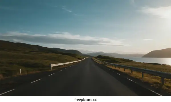 A scenic road stretching through open countryside under a clear sky