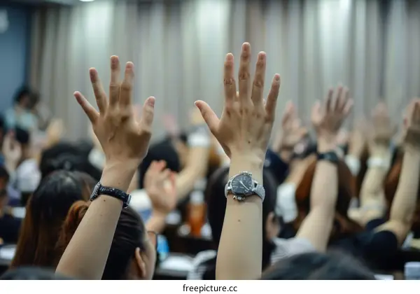 A group of people raising their hands in a classroom